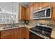 Well-equipped kitchen features stainless steel appliances, wooden cabinetry, and tiled backsplash at 3711 Ramblewood, Durham, NC 27713