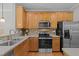 Well-lit kitchen featuring stainless steel appliances, light wood cabinetry, and laminate countertops at 3711 Ramblewood, Durham, NC 27713