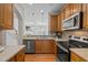 Well-equipped kitchen with stainless steel appliances, a sink overlooking the fireplace, and wooden cabinets at 3711 Ramblewood, Durham, NC 27713