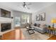 Bright living room with fireplace, ceiling fan, modern decor, and access to outdoor space at 3711 Ramblewood, Durham, NC 27713