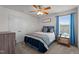 Stylish bedroom with shiplap accent wall, ceiling fan, closet, and a side table with blue curtains at 3936 White Kestreg Dr Dr, Raleigh, NC 27616