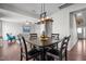 Open-concept dining area with modern chandelier and hardwood floors throughout the room and into the living room at 3936 White Kestreg Dr Dr, Raleigh, NC 27616