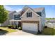 Attractive two-story home featuring stone accents, blue shutters, an attached two-car garage, and professional landscaping at 3936 White Kestreg Dr Dr, Raleigh, NC 27616