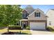 Charming two-story home with stone accents, blue shutters, a well-manicured lawn, and an attached two-car garage at 3936 White Kestreg Dr Dr, Raleigh, NC 27616