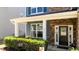Close-up of the front porch and entrance featuring stone accents, white columns, and well-maintained landscaping at 3936 White Kestreg Dr Dr, Raleigh, NC 27616