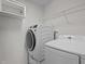 Modern laundry room featuring front load washer, top load dryer, wire rack shelving, and storage cabinet at 3936 White Kestreg Dr Dr, Raleigh, NC 27616