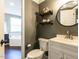 Elegant bathroom featuring a stylish vanity, a round mirror, and decorative shelves with cute accents at 404 Woodstar Dr, Cary, NC 27513