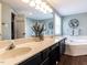 Luxurious bathroom boasts a double sink vanity, soaking tub, tiled shower, and elegant decor with modern fixtures at 404 Woodstar Dr, Cary, NC 27513