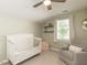 Charming Bedroom with vaulted ceilings, crib, glider, and shelving providing a cozy, and functional space at 404 Woodstar Dr, Cary, NC 27513