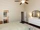 Bright bedroom featuring ceiling fan, ensuite bath, large dresser, and serene decor provides ample space and comfort at 404 Woodstar Dr, Cary, NC 27513