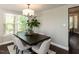 Cozy dining room with modern chandelier, dark wood table, and window overlooking backyard at 404 Woodstar Dr, Cary, NC 27513