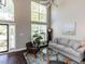 Bright living room with two-story windows, dark wood floors, and neutral-toned furniture at 404 Woodstar Dr, Cary, NC 27513