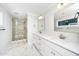 Bright bathroom featuring double vanity with white cabinets, marble floors, and a glass shower with a built in bench at 407 Carolina Ave, Raleigh, NC 27606