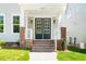 Front porch featuring brick stairs, white columns, and a black front door with glass panels at 407 Carolina Ave, Raleigh, NC 27606