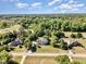 Aerial view of a suburban neighborhood, showcasing homes, mature trees, and a nearby green landscape at 4117 Stansted Dr, Fuquay Varina, NC 27526