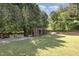 Green backyard with stone gravel, play set and patio seating, perfect for relaxation and play at 4117 Stansted Dr, Fuquay Varina, NC 27526