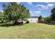 Large, grassy backyard featuring mature trees, a wooden fence, and an inviting outdoor space at 4117 Stansted Dr, Fuquay Varina, NC 27526
