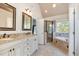 Bright primary bath featuring dual sinks, granite countertops, glass shower, and soaking tub at 4117 Stansted Dr, Fuquay Varina, NC 27526