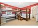 This bedroom features a wooden bunk bed with a built-in desk and an adjacent door, with red accent wall at 4117 Stansted Dr, Fuquay Varina, NC 27526