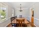 Formal dining room featuring hardwood floors, wainscoting, a rustic wooden table and a chandelier at 4117 Stansted Dr, Fuquay Varina, NC 27526