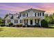 Traditional two-story home with a welcoming front porch, black shutters, and manicured landscaping at 4117 Stansted Dr, Fuquay Varina, NC 27526