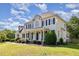 Spacious two-story home featuring black shutters, a covered front porch, and verdant landscaping at 4117 Stansted Dr, Fuquay Varina, NC 27526