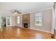 Bright living room with a stone fireplace, hardwood floors, and a ceiling fan at 4117 Stansted Dr, Fuquay Varina, NC 27526