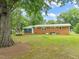 Large backyard with brick home, mature trees, and fenced perimeter at 413 Winterlochen Rd, Raleigh, NC 27603