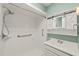 Bathroom featuring tiled shower with safety bars, single sink vanity with storage at 413 Winterlochen Rd, Raleigh, NC 27603