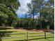 Scenic park lake view with walking trail surrounded by lush trees at 413 Winterlochen Rd, Raleigh, NC 27603
