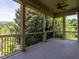 Spacious covered porch with outdoor seating, ceiling fan, and scenic views of the surrounding lush greenery at 4143 Gardenlake Dr, Raleigh, NC 27612