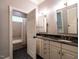 This bathroom features double sinks, granite countertops, and a tub with a shower behind a partially open door at 4143 Gardenlake Dr, Raleigh, NC 27612