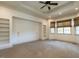 Cozy bedroom with neutral carpet, built-in shelving, and multiple windows for natural light at 4143 Gardenlake Dr, Raleigh, NC 27612
