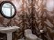This powder room features eye-catching wallpaper with a botanical pattern and a floating glass shelf at 4143 Gardenlake Dr, Raleigh, NC 27612