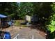 Backyard featuring mature trees, storage buildings, and a partially covered trailer at 418 Madison Ave, Cary, NC 27513