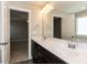 Bathroom with dual sinks, dark cabinets, a large mirror, and ample lighting at 43 Jonalker Ct, Clayton, NC 27520