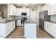 Well-lit kitchen with white cabinetry, stainless steel appliances, and a kitchen island with granite countertops at 43 Jonalker Ct, Clayton, NC 27520