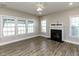 Inviting living room with a cozy fireplace, large windows, and modern flooring at 43 Jonalker Ct, Clayton, NC 27520