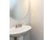 Elegant pedestal sink with a round mirror and clean design in a half bathroom at 43 Jonalker Ct, Clayton, NC 27520