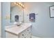 Bathroom with vanity, light blue walls, marble countertop, updated fixtures, and decorative towel at 4420 Dula St, Durham, NC 27705