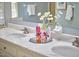 Close-up of bathroom vanity showcasing marble countertop, decorative flowers, and dual sinks with updated fixtures at 4420 Dula St, Durham, NC 27705