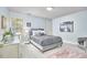 Cozy bedroom features stylish decor, neutral carpet, and a comfortable bed with decorative pillows at 4420 Dula St, Durham, NC 27705