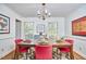 Bright dining room with a wooden table, pink chairs, two large windows and modern art at 4420 Dula St, Durham, NC 27705