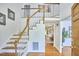 Sunlit foyer features hardwood floors, a white staircase, and an open view into the living spaces at 4420 Dula St, Durham, NC 27705