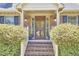 Inviting front porch with brick steps, decorative plants, and a wooden door, offering curb appeal at 4420 Dula St, Durham, NC 27705