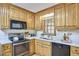 Traditional kitchen with wood cabinets, black appliances, and light countertops at 4420 Dula St, Durham, NC 27705