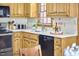 Kitchen with wood cabinets, stainless steel stove, and black dishwasher at 4420 Dula St, Durham, NC 27705