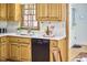 Kitchen with wood cabinets, a black dishwasher, and a stainless steel faucet at 4420 Dula St, Durham, NC 27705