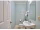 Light and airy half-bathroom with pedestal sink, white fixtures, and pale blue walls at 4420 Dula St, Durham, NC 27705