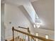 View of open staircase with wood treads, white risers, and a modern chandelier illuminating the foyer at 4420 Dula St, Durham, NC 27705